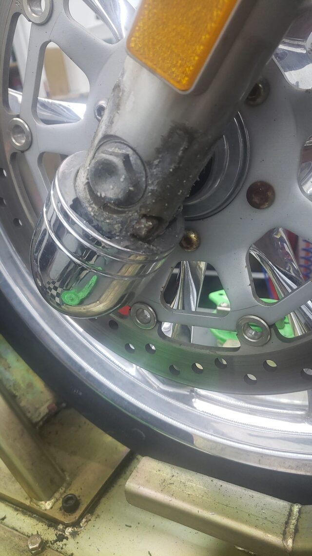 Close-up of a front fork and brake caliper during service